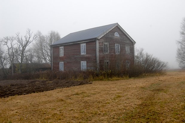 Kläppe 5:3. Hus i tre våningar i brun, liggande panel, fönster med grå spröjs.