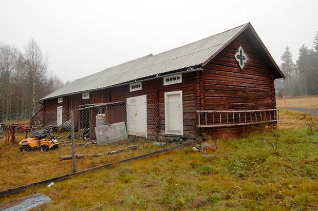 Sjör 1:5. Byggnad i rött timmer, två vita portar och en vit dubbelport.