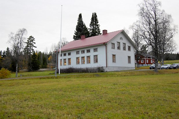 Häggenås Prästbord 1:7. Vit villa i tre våningar, grå detaljer, fönster med röda spröjs.