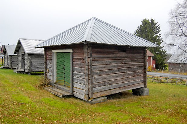 Gungård 1:22. Byggnad i grått timmer med grön dubbelport.