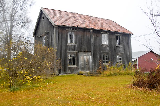 Häggenås-Högen 1:24. Villa i grå panel i två våningar, grå dubbeldörr, fönster med spröjs.