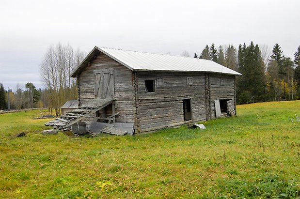 Häggesta 1:108. Ladugård i grått timmer med dubbelport och öppna luckor.