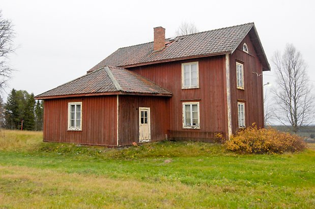 Storgård 1:31. Hus i röd panel i två våningar, tillbyggnad på långsidan, fönster med vita spröjs och vit dörr.