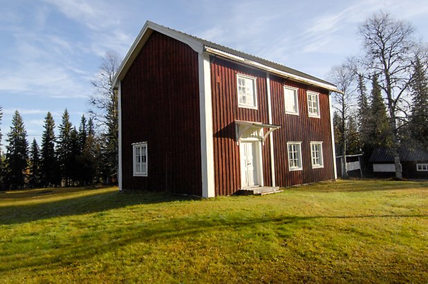 Storhögen 4:13. Hus i två våningar i röd panel, vit dubbeldörr och fönster med vita spröjs.