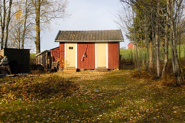 Storhögen 8:1. Byggnad i röd panel med två gula portar.