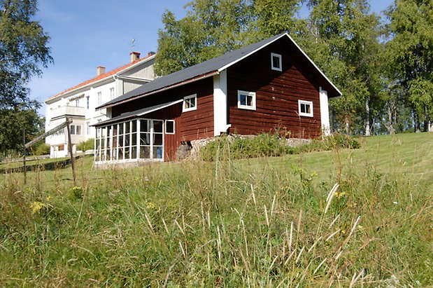 Kungsgården 5:6. Hus i rött timmer, drivhus byggt längs långsidan.