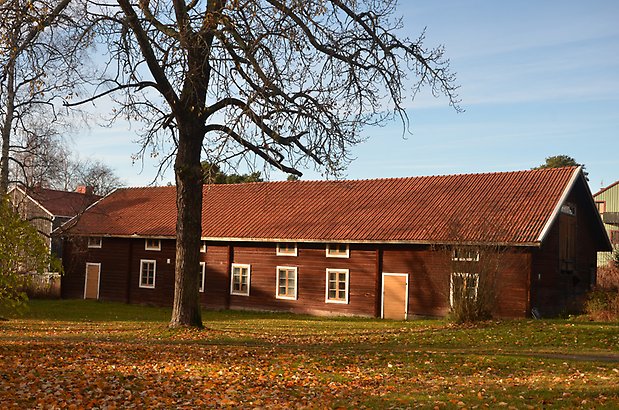 Odenslund 4:3. Timrad röd byggnad med gula dörrar och vita fönster med gula spröjs. 