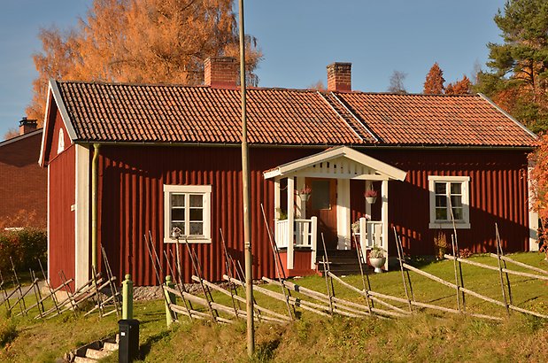 Berghem 10 a. Villa med röd panel och vitt fönster med spröjs och förstukvist.