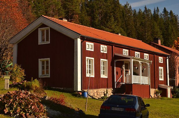 Berghem 10 b. Villa med röd panel och vitt fönster med spröjs och förstukvist.