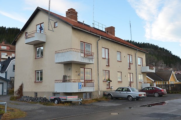 Bergsvik 9. Bostadshus i tre våningar med ljusgul puts, röda fönster och vit balkonger.