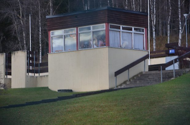 Frösö Berge 21-212. Byggnad i beige puts, panel i rött och brunt och vita fönster runt om.