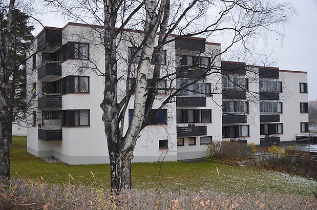 Dalhem 4. Bostadshus i vit puts med svarta fönster och balkonger.