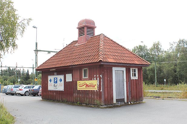 Brunflo-Änge 1:53. Byggnad i röd panel, litet vitt fönster med spröjs, grå dörr, tegeltak och stor skorsten.