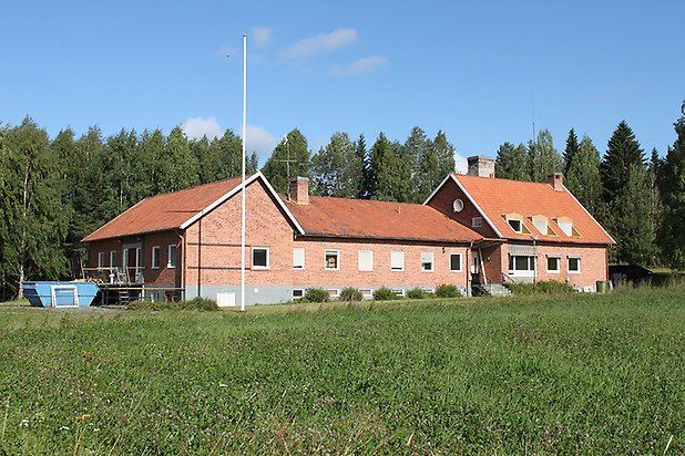 Byggnad i tegel med vita fönster.