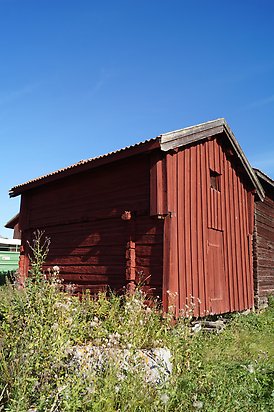 Ope 3:12. Byggnad i röd panel med röd port.