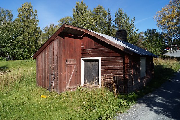 Torvalla 3:33. Timrad, brun byggnad med ett tillbyggt dass.