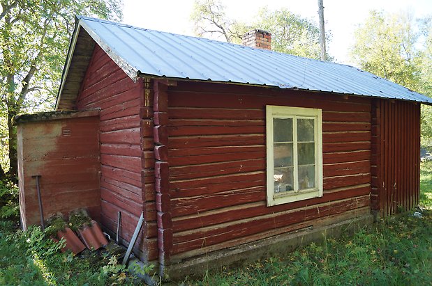 Vamsta 7:2. Stuga i rött timmer, fönster med vita spröjs.