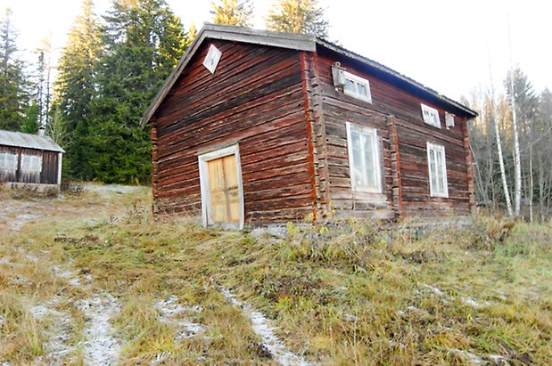 Lockne-Berge 1:2. Hus i brun/rött timmer i två våningar, fönster med vita spröjs och gul dubbeldörr.