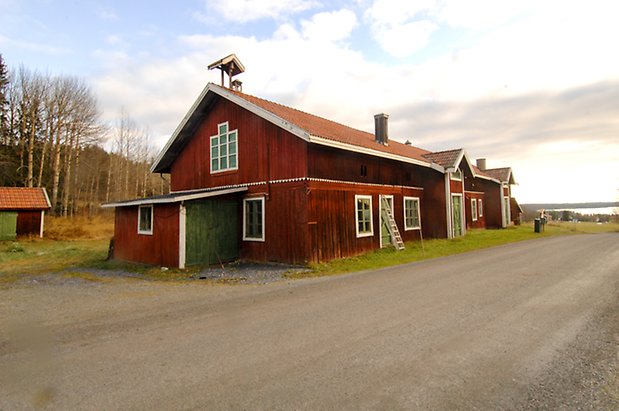 Lockne-Änge 2:9. Ladugård i röd panel i två våningar, med gröna portar och dubbelportar, fönster med gröna spröjs.