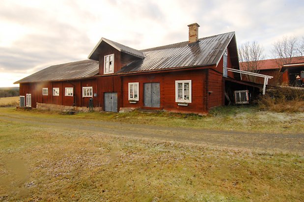 Ångsta 2:2. Byggnad i rött timmer och panel, två blå dubbelportar och två blå portar, vita fönster med spröjs.