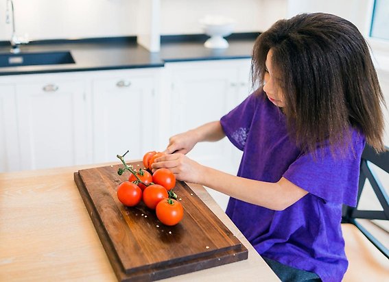 Barn skär tomater