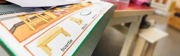 Barn i oskärpa bakom utbildningsmaterial.