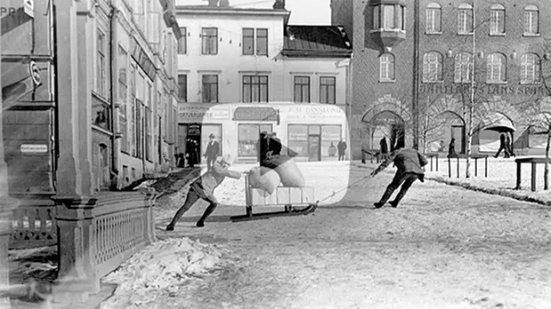 Föreställer två pojkar som drar en släde på Stortorget i Östersund