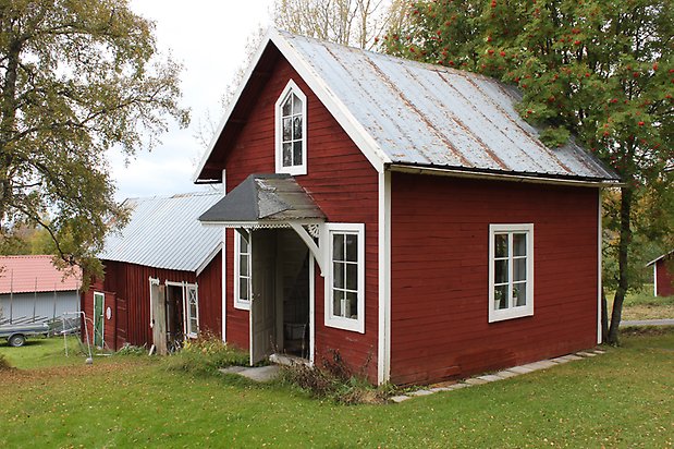 Spinetten 1. Hus i röd liggande panel, vita fönster med spröjs.