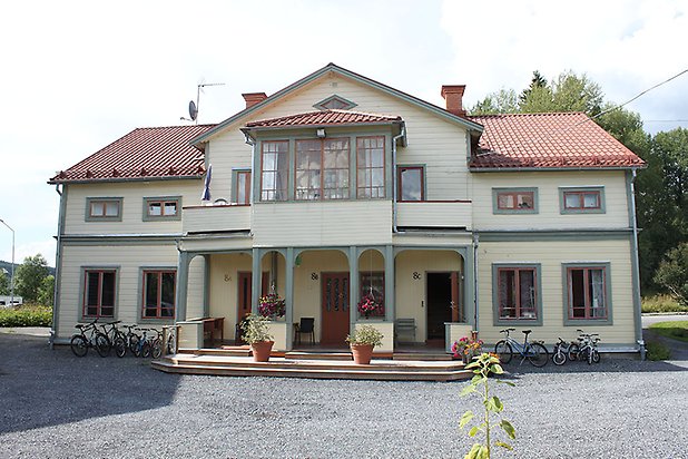 Söre 2:158. Villa i ljusgrön, liggande panel med gröna detaljer och gröna fönster med röda spröjs Förstukvist och inglasad balkong.