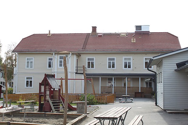 Söre 3:60. Byggnad i ljusgul, liggande panel med vita fönster, femkantig utbyggnad och veranda.